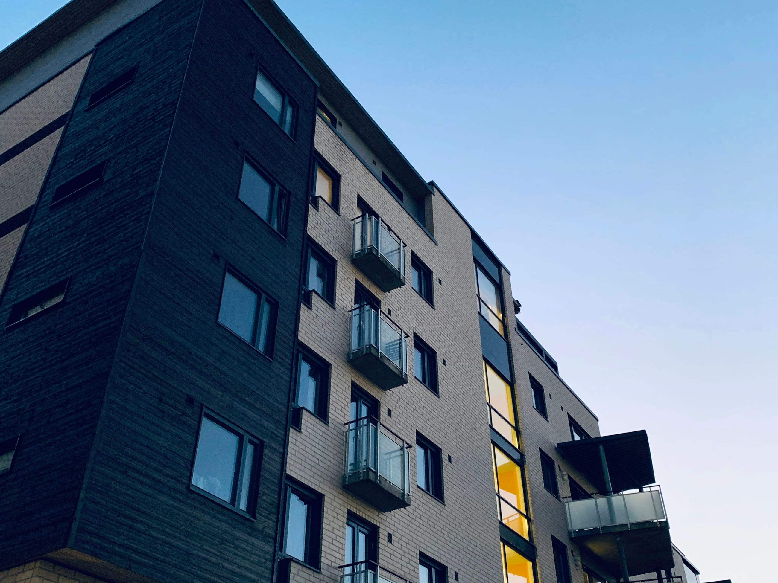Saniertes Mehrfamilienhaus mit hellem Klinker und dunkler Holzverkleidung