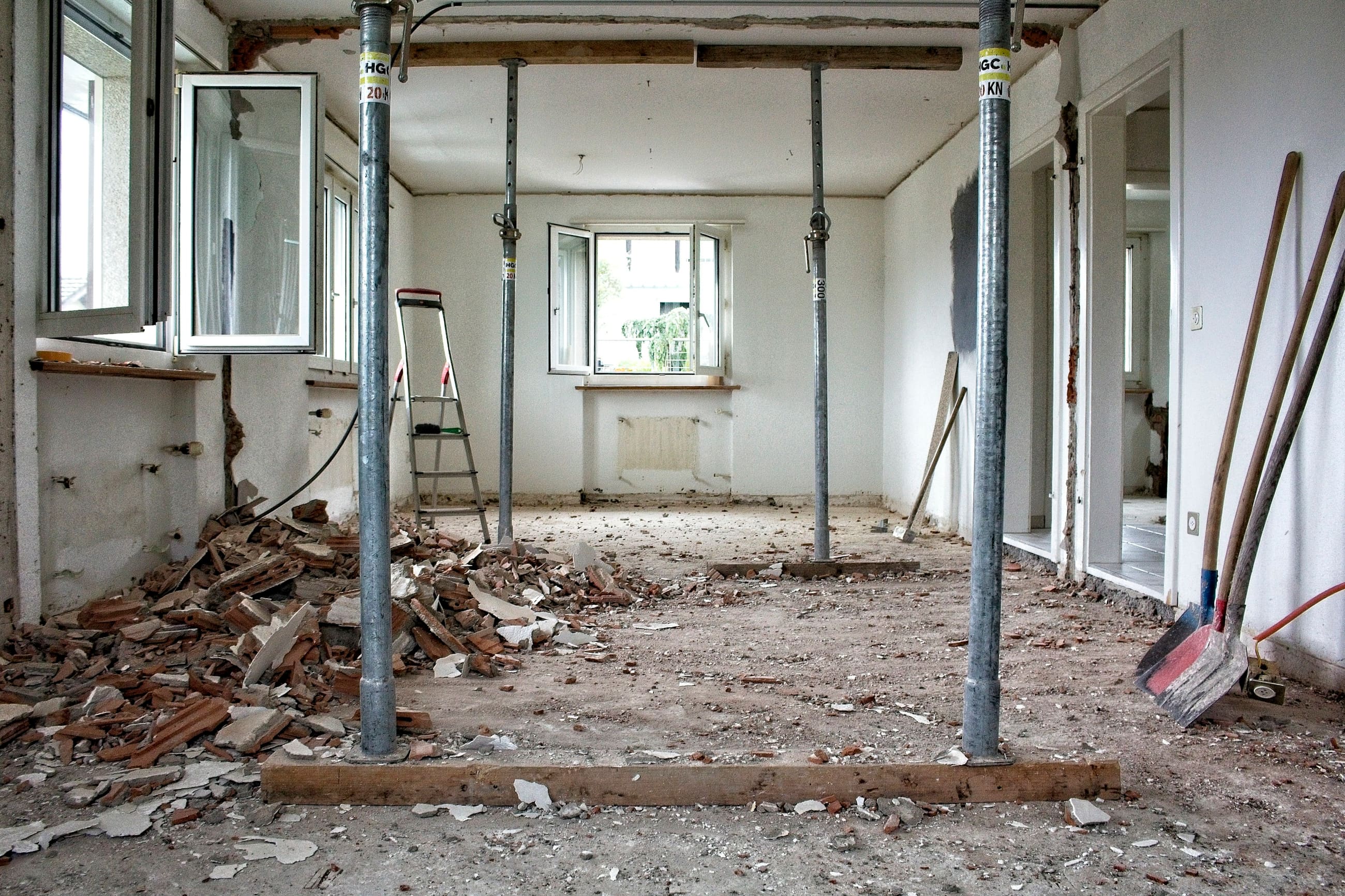 Entkernter Raum in der Rohbauphase, abgestützte Decke und aufgebrochener Boden